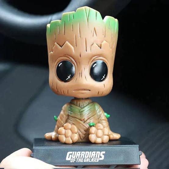 Green novelty bobblehead figure displayed on flat surface