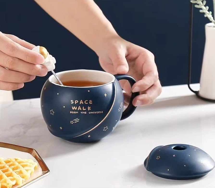 Space-theme mug with stirrer displayed on table