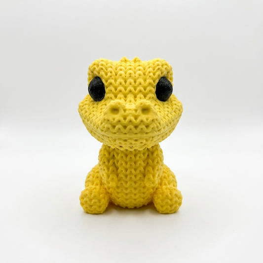 Knitted yellow dinosaur miniature toy, front view